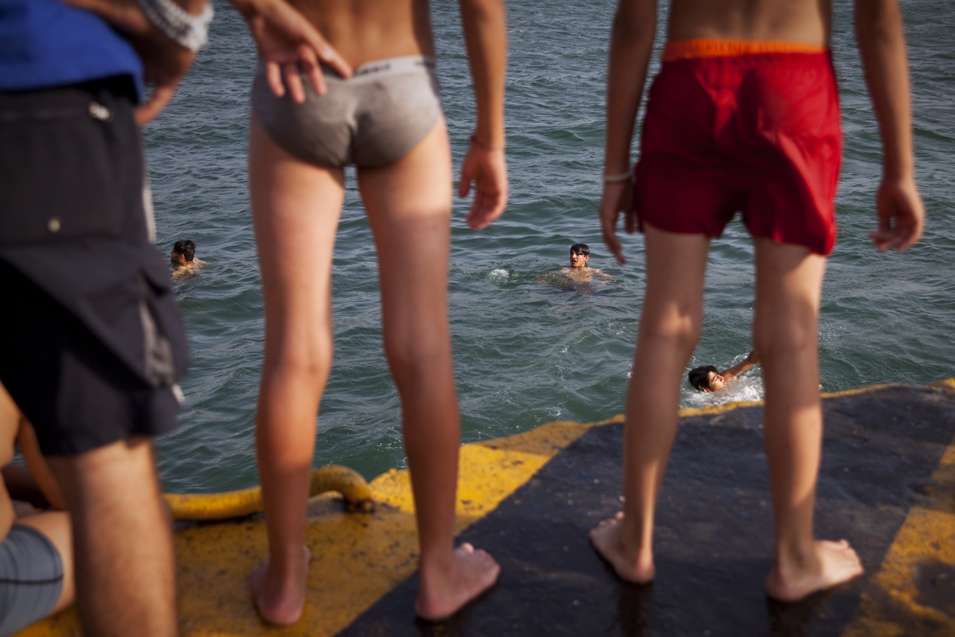 Bien que cela soit interdit, les jeunes hommes n’hésitent pas à plonger dans le port pour se rafraîchir et s’amuser.